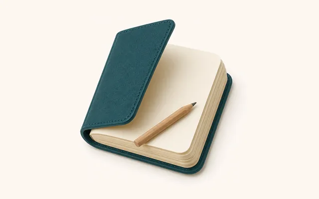 A teal travel journal with a pencil